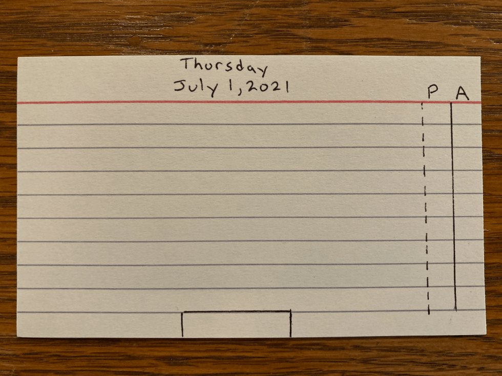 A blank index card with the day and date written at the top and two narrow columns, P and A, ruled down the right edge
